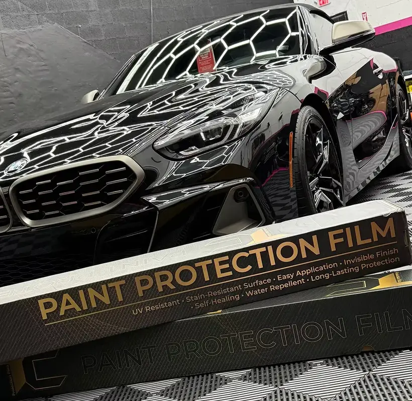 Close-up of clear paint protection film being installed on a car panel at the Tasha Miami shop